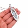 Reverso del colgante articulado de plata 925 con dos piedras de larimar, mostrado con cadena sobre la mano