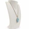 Cadena mostrada solo como referencia; no incluida en el precio. Colgante ovalado de larimar azul en plata 925 presentado en busto blanco; la cadena se muestra solo como referencia